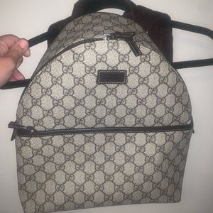 Authentic Gucci small GG Supreme canvas backpack, w brown leather details.